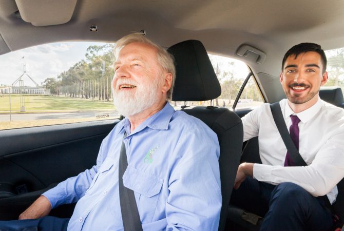 Passneger and Canberra Elite driver laughing inside Taxi